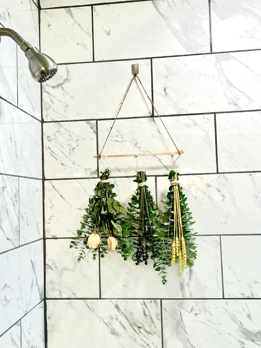 Shower eucalyptus bundle hanging in a marble tiled shower.